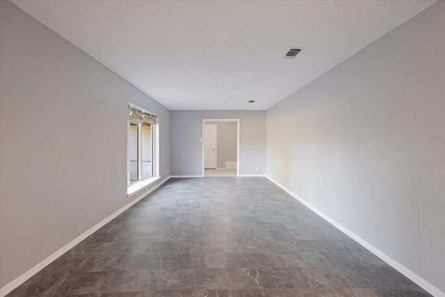 unfurnished room with visible vents, concrete floors, and baseboards