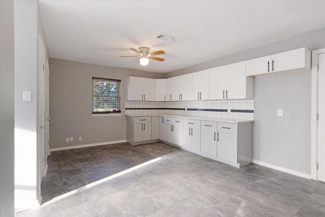 kitchen with decorative backsplash, light countertops, baseboards, and visible vents