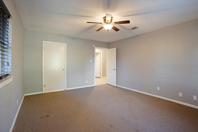 carpeted spare room with ceiling fan and a textured ceiling