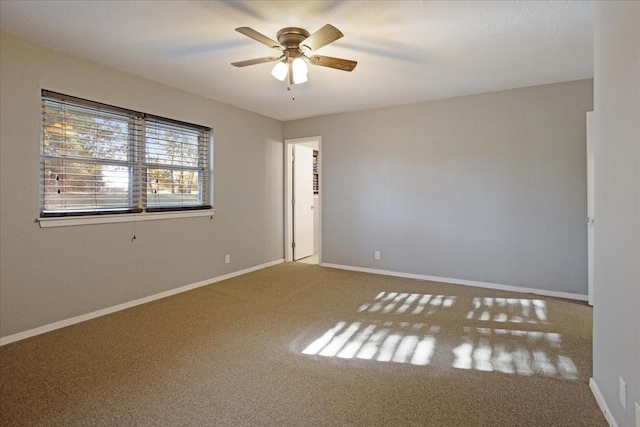 unfurnished room with baseboards, ceiling fan, and carpet floors