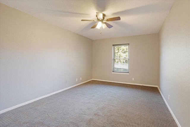empty room with carpet flooring, baseboards, and ceiling fan