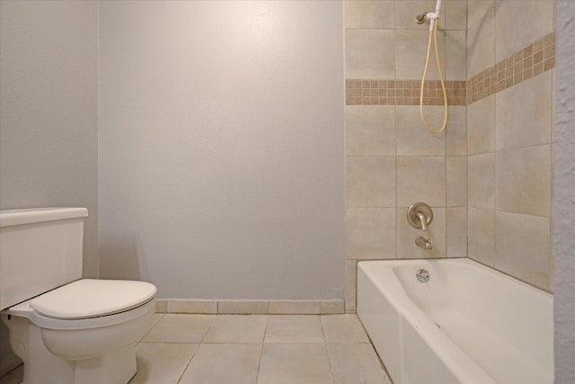 bathroom with tiled shower / bath combo, tile patterned floors, and toilet