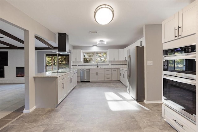 kitchen with tasteful backsplash, visible vents, appliances with stainless steel finishes, island range hood, and a sink
