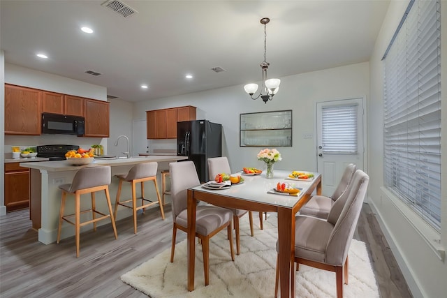 dining space with light wood-style flooring, visible vents, and recessed lighting