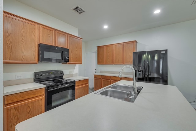 kitchen featuring recessed lighting, light countertops, visible vents, a sink, and black appliances