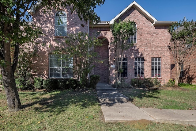 view of front of property with a front yard and brick siding