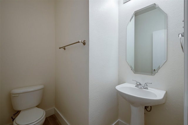 half bath with toilet and baseboards