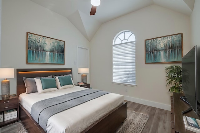 bedroom featuring a ceiling fan, baseboards, vaulted ceiling, and wood finished floors