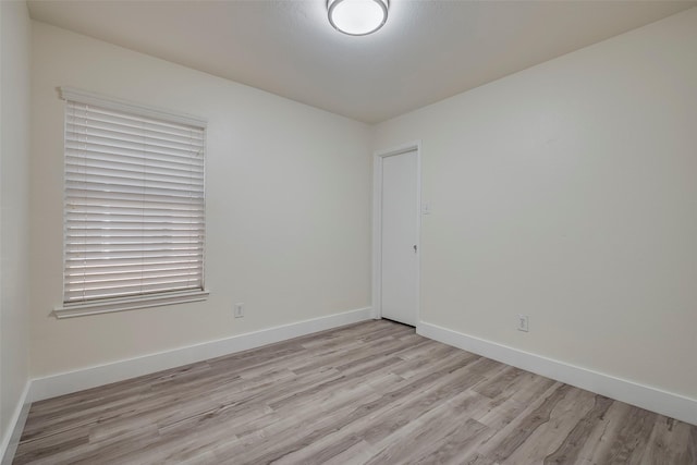 spare room with light wood-style flooring and baseboards