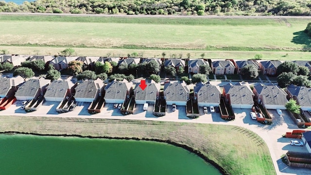 view of property's community with a residential view, a water view, and a lawn