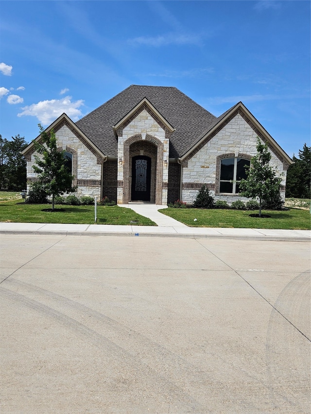 french provincial home featuring a front lawn