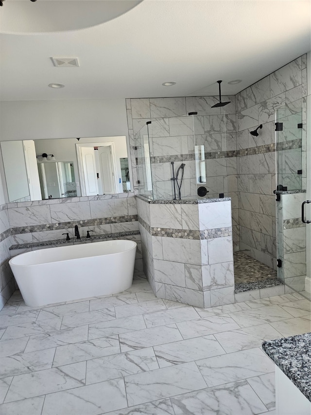 bathroom with tile walls, vanity, and independent shower and bath