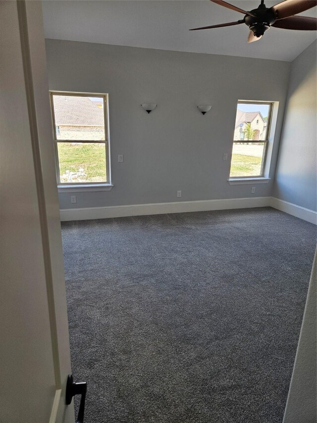 carpeted empty room with a wealth of natural light and ceiling fan