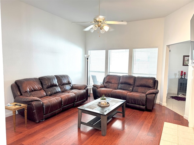 living room with ceiling fan and dark wood-type flooring