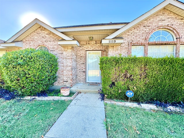 view of exterior entry with a lawn