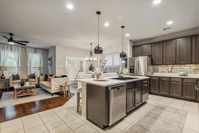 kitchen featuring sink, light tile patterned floors, pendant lighting, and appliances with stainless steel finishes