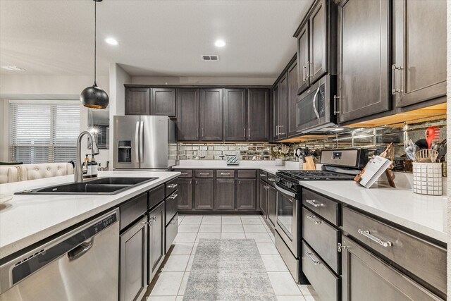 kitchen with pendant lighting, stainless steel appliances, dark brown cabinets, and sink