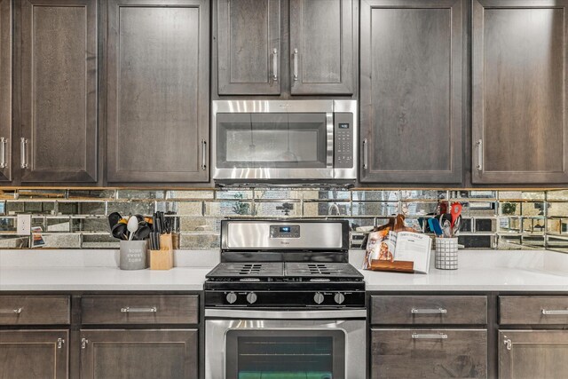 kitchen with dark brown cabinets, stainless steel appliances, and tasteful backsplash