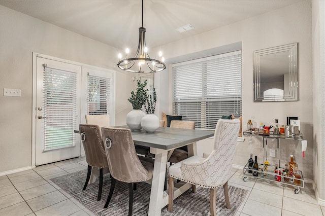 dining space featuring light tile patterned floors and a notable chandelier