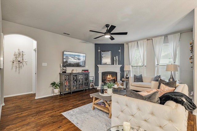 living room featuring ceiling fan and dark wood-type flooring