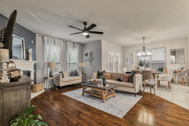 living room featuring dark hardwood / wood-style floors, a textured ceiling, and ceiling fan with notable chandelier