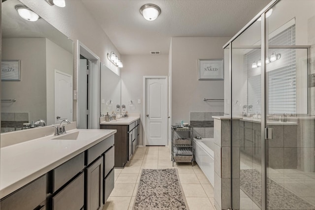 bathroom with tile patterned floors, vanity, plus walk in shower, and a textured ceiling