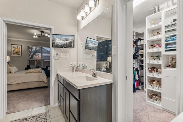 bathroom featuring tile patterned floors, vanity, crown molding, and a textured ceiling