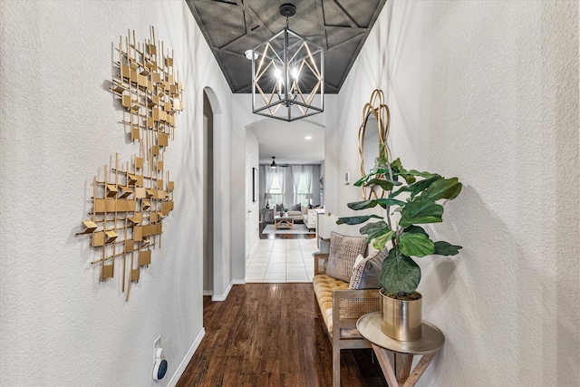 hallway featuring hardwood / wood-style flooring and an inviting chandelier