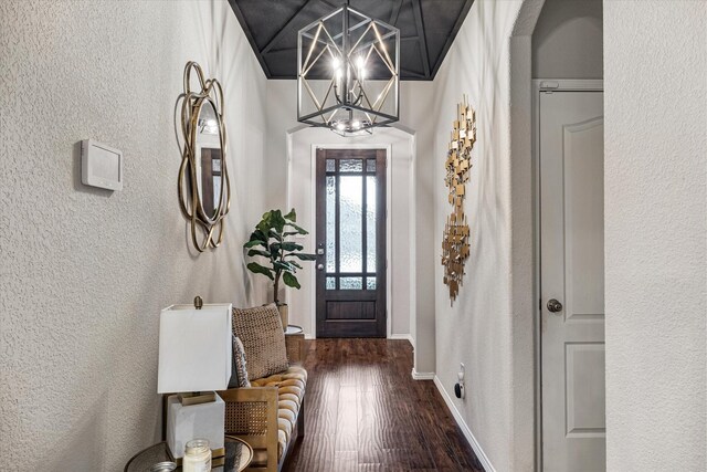 foyer featuring dark hardwood / wood-style floors, crown molding, and a notable chandelier