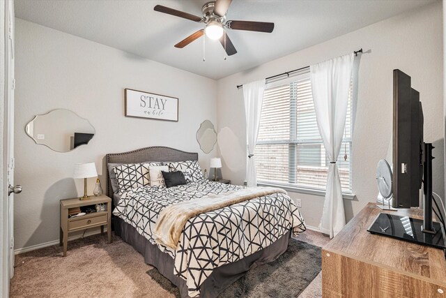 carpeted bedroom featuring ceiling fan and multiple windows