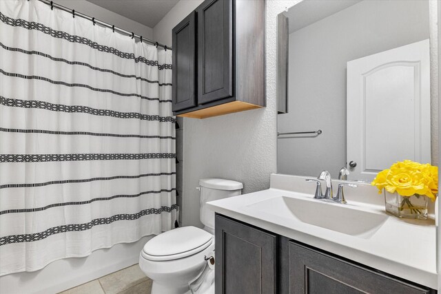 full bathroom featuring toilet, shower / bath combination with curtain, vanity, and tile patterned floors