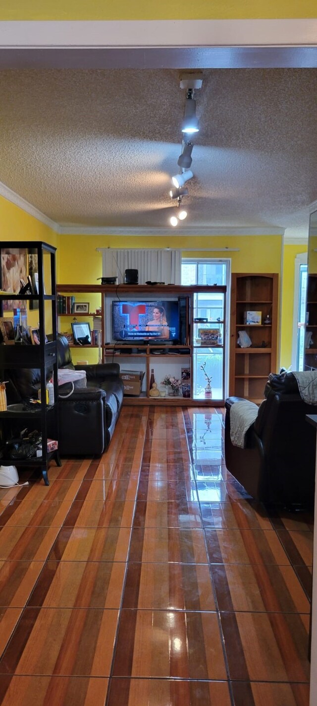 tiled living room featuring crown molding, ceiling fan, and a textured ceiling