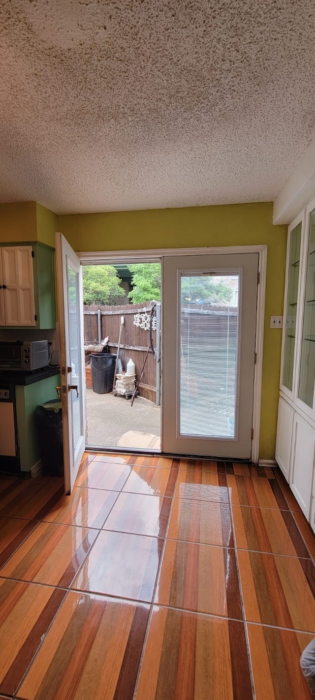 doorway with light tile patterned flooring and a textured ceiling