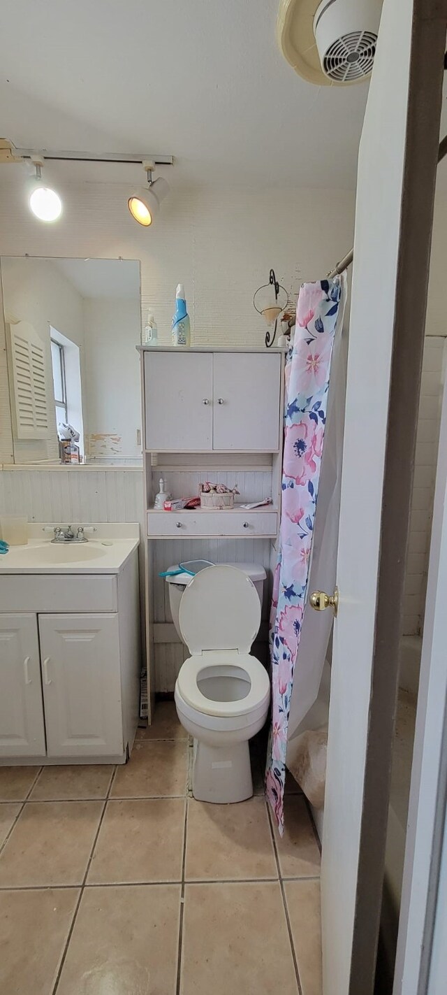 bathroom featuring tile patterned flooring, vanity, toilet, and walk in shower