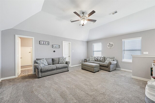 living area with lofted ceiling, baseboards, visible vents, and light colored carpet