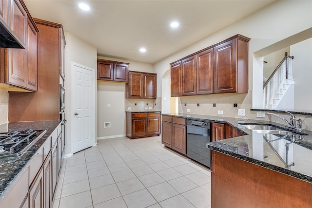 kitchen with dark stone counters, black dishwasher, stainless steel gas cooktop, sink, and tasteful backsplash