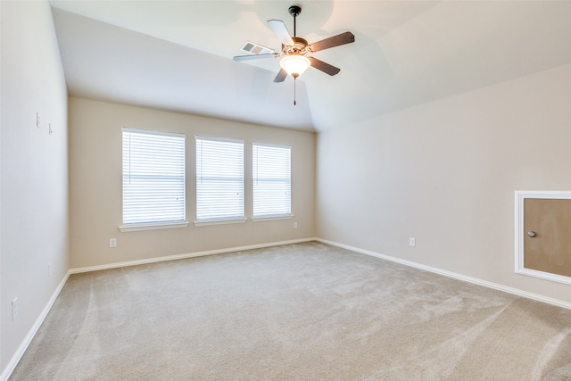 empty room featuring ceiling fan, light carpet, and vaulted ceiling