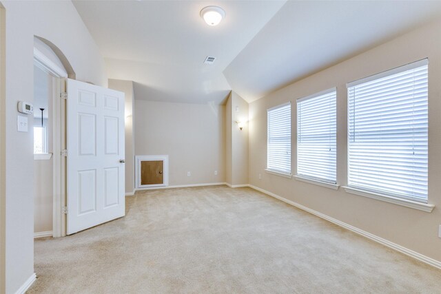 spare room with lofted ceiling and light colored carpet