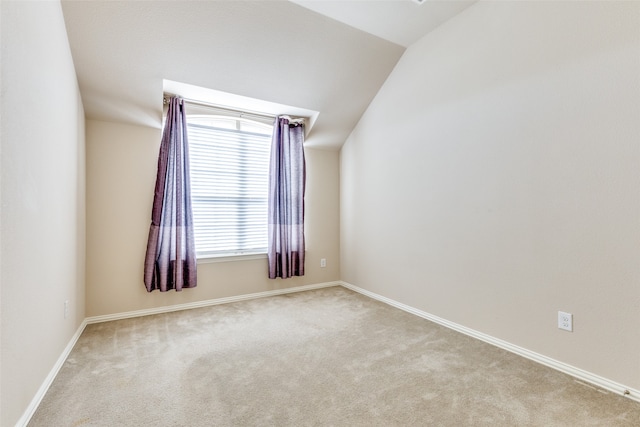 empty room with lofted ceiling and light carpet