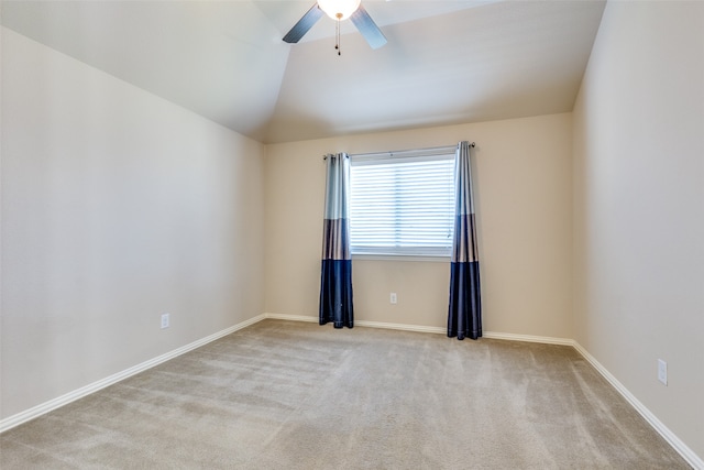 carpeted spare room featuring ceiling fan and vaulted ceiling