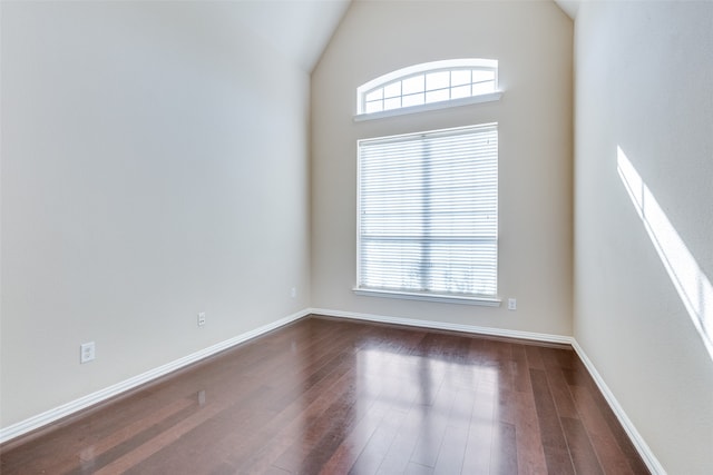 unfurnished room featuring dark wood-type flooring and vaulted ceiling