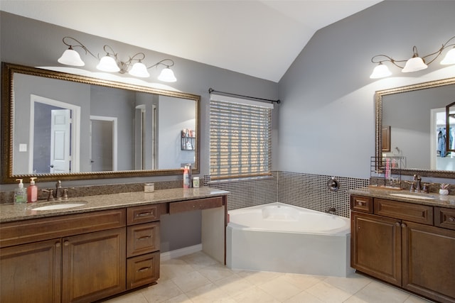 bathroom featuring a bathing tub, vanity, tile patterned floors, and lofted ceiling