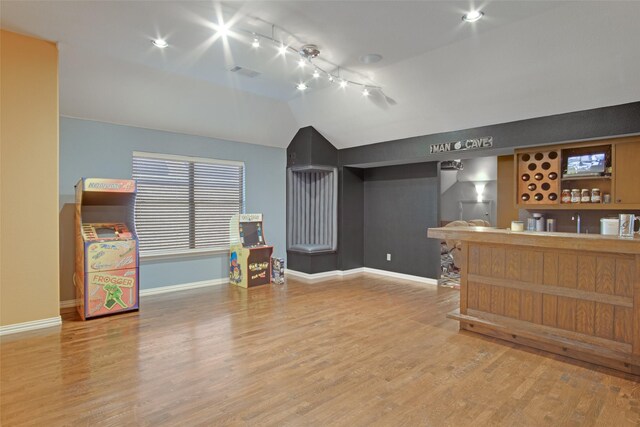 interior space featuring hardwood / wood-style flooring, track lighting, lofted ceiling, and sink