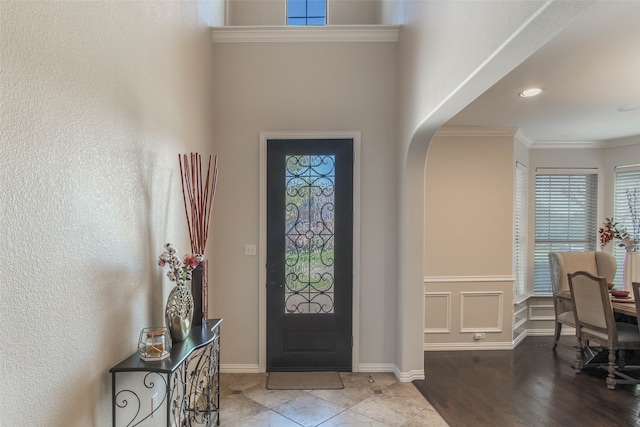 foyer with hardwood / wood-style floors and crown molding