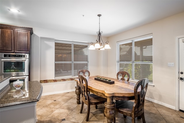 dining area with a chandelier and light tile patterned floors