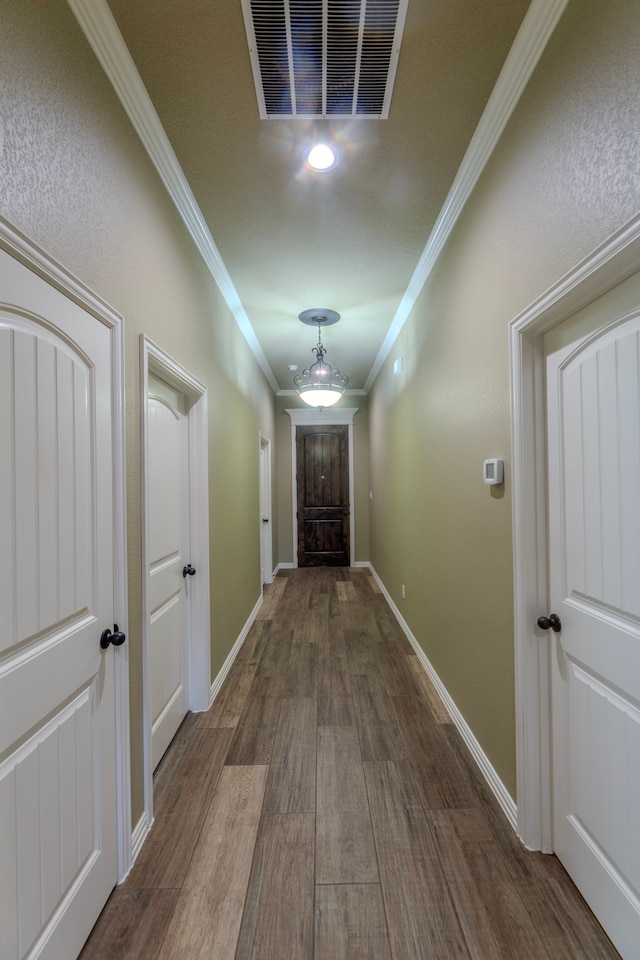 hall with wood-type flooring and ornamental molding