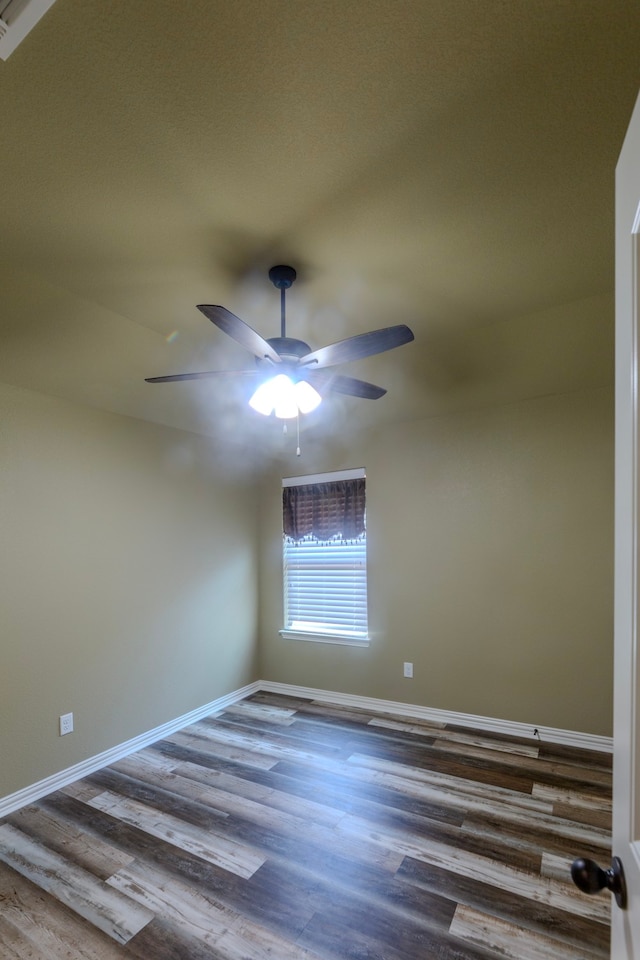 spare room featuring dark wood-type flooring and ceiling fan