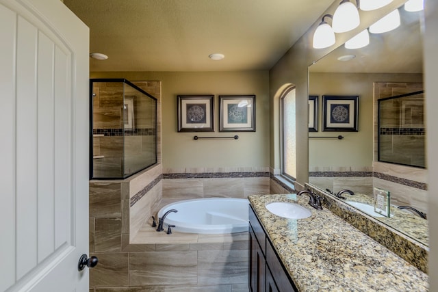 bathroom with shower with separate bathtub and vanity