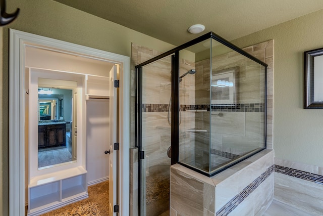 bathroom with walk in shower and a textured ceiling