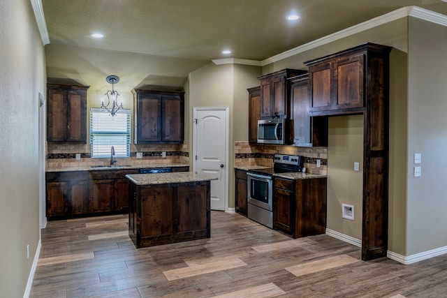 kitchen featuring backsplash, sink, a kitchen island, and appliances with stainless steel finishes